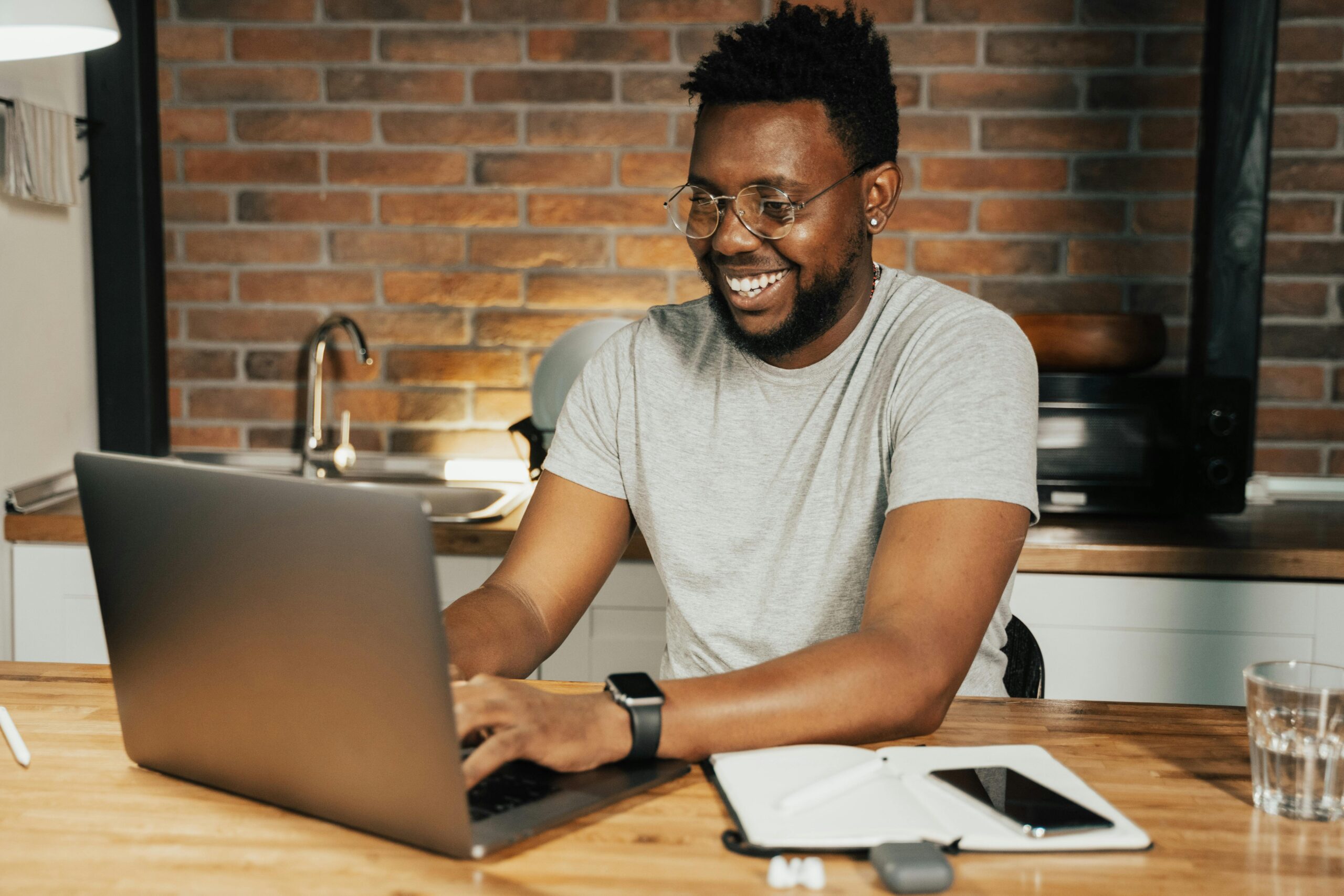 Happy man smiling at a computer, ready fro radiology board certification preparation with Dr. Linda Carr.