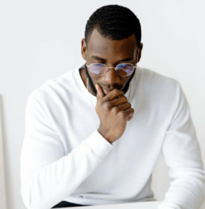 Black man with glasses and a white shirt is studying for his medical specialty board exam using the metacognition approach.